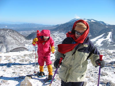 浅間山をバックに山頂に到着したメンバーの写真