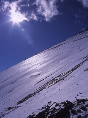 輝く太陽と雪の斜面の写真