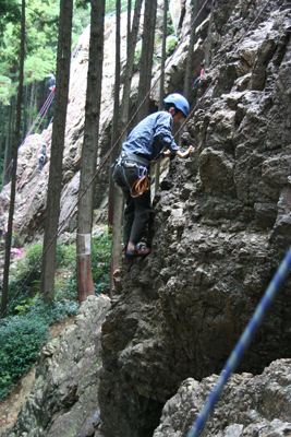 女岩南面の３級ルート左側を登るKさんの写真
