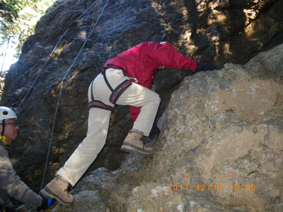登山靴でさらに岩を登っているＭさんの写真