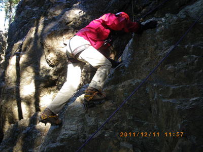 アイゼンで岩を登っているＭさんの写真