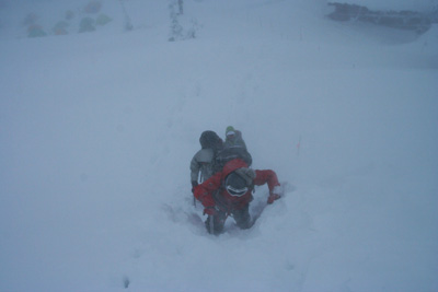 吹雪の中、急斜面を登ってくる写真