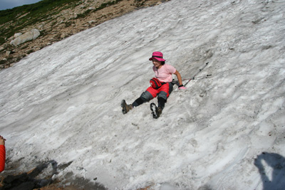 雪渓を尻で滑っているＦさんの写真
