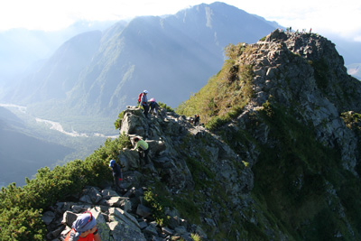 独標からの痩せた岩稜を歩く人の写真