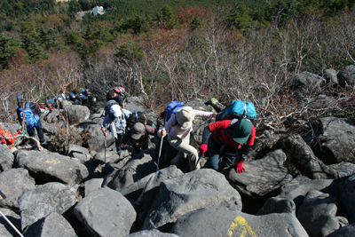 蓼科山荘を見下ろし、大岩のところを登っている写真