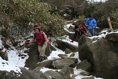 女体山から雪の多い登山道を下っている写真