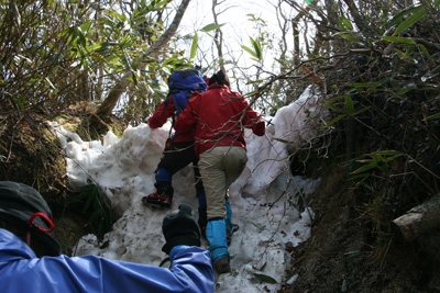 鎌ヶ岳に向けて雪壁のようなところを登っている写真