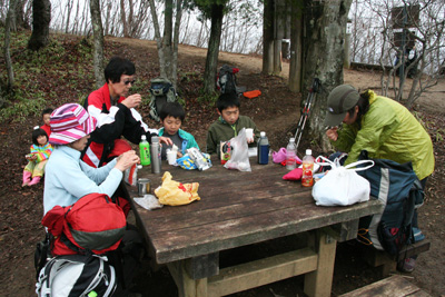 三国山のテーブルで昼食中のメンバーの写真