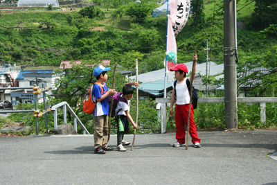 芦ヶ久保駅で長い棒を持つ３人の子どもたちの写真