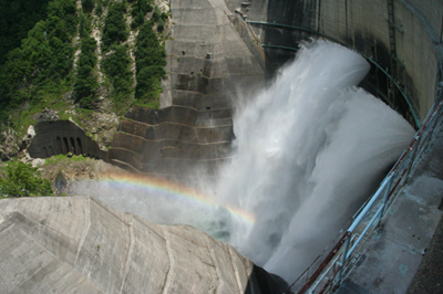 黒部ダムの放流と虹の写真