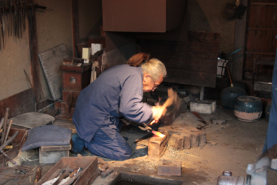 包丁作りの鍛冶屋さんが熱した鉄を叩いている写真