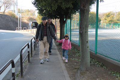 村上緑地公園に向けて手をつないで歩いている写真