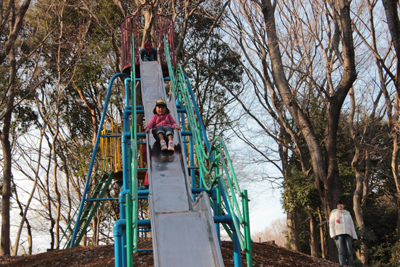 村上緑地公園にある長い滑り台を滑るAちゃんの写真