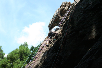 男岩南面フェースの上部を登るM.Kさんの写真
