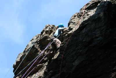 男岩南面フェースの最上部かぶり気味のクラックを登るM.Kさんの写真