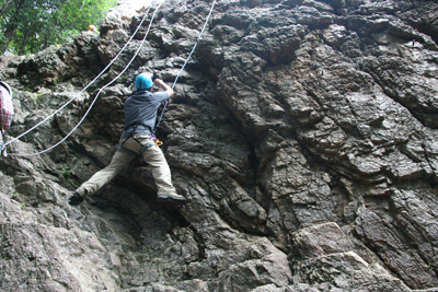 男岩西面フェースの下部を登るSさんの写真