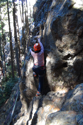 登山靴で女岩南面を登り始めるＦさんの写真