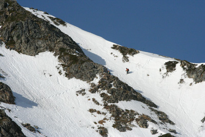 急傾斜の雪面をトラバースしている人の写真