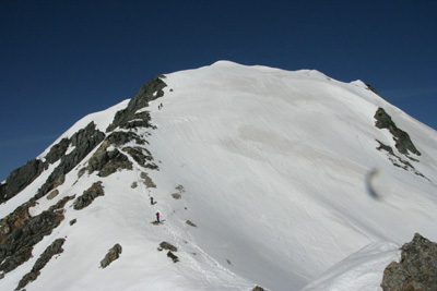 五竜岳山頂直下の雪壁を登っている人たちの写真
