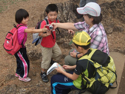 天覧山の山頂でＫさんの周りに集まった子どもたちの写真