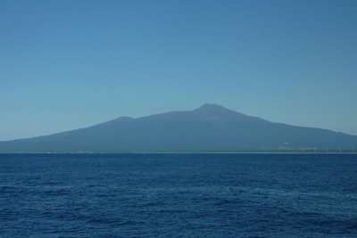 飛島付近から見た海を隔てた鳥海山の写真