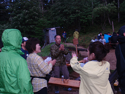 YMさんが撮影した山小屋の外で大阪の人たちと歌を歌っている写真