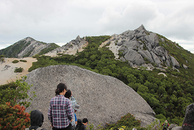 薬師岳と観音岳を前に見て、岩場を下っている写真
