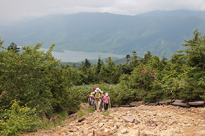 有峰湖を背に登っている写真
