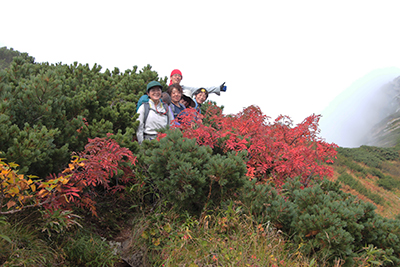 クロユリのコル付近のナナカマドの紅葉とメンバーの写真