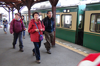 江ノ島駅で江ノ電の電車を降りてホームを歩いている写真