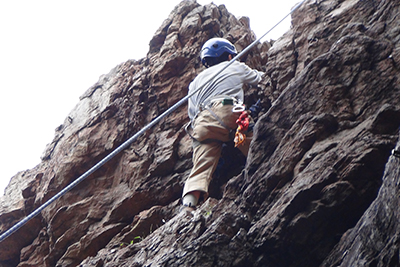 男岩南面フェースの最上部を登るＫさんの写真