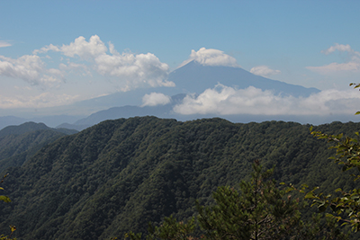 頭を雲に隠した富士山の写真