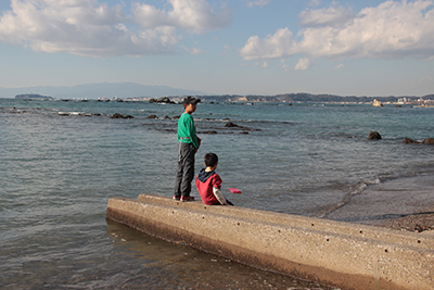 念願の海岸について何をして遊ぶか思案している子どもたちの写真