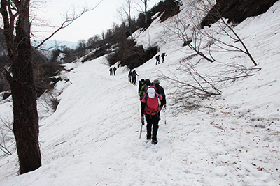 深い雪の道を登っているメンバーの写真