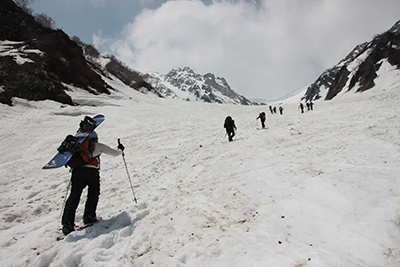 大雪渓を登る人たちを下から撮った写真