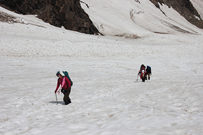 強い日差しの下で大雪渓を登っているメンバーの写真