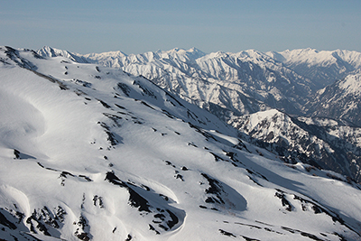 旭岳の山腹から見た槍穂高連峰方面の写真