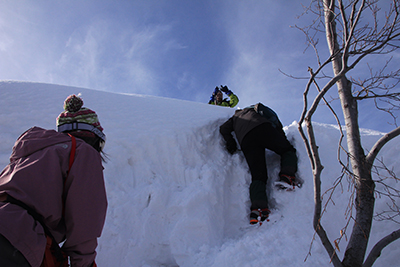 雪壁を登るKさんの写真