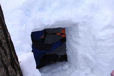 雪洞を掘っているTさんの写真