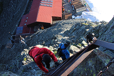 穂高岳山荘の上のはしごを登ってくる人を上から撮った写真