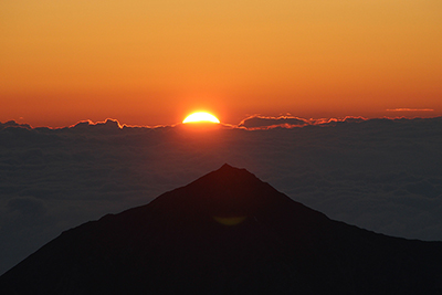 常念岳山頂の上から登る朝日の写真