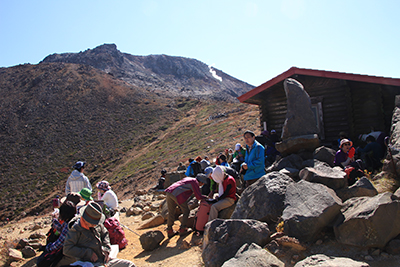 峰の茶屋跡避難小屋の外で昼食中の写真