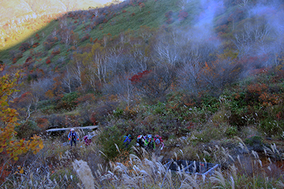 三斗小屋温泉の源泉の蒸気を横に見ながら登っている写真