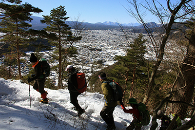 積雪で白くなった富士吉田の町を見ながら登っている写真