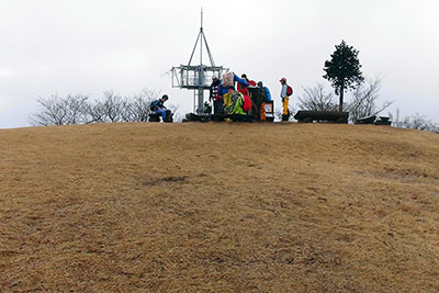 広い堂平山の山頂に集まったメンバーの写真
