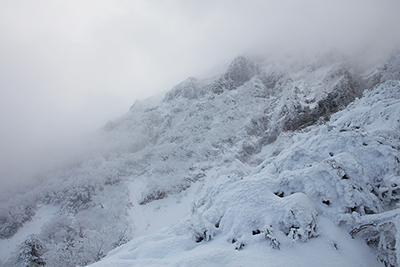 霧の中に一瞬見えた赤岳西壁の写真