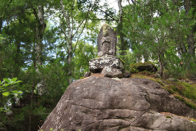 林道途中にある岩の上に奉られている道祖神の写真