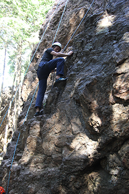 岩登り初体験のＫ君のお父さんが女岩南面を登っている写真