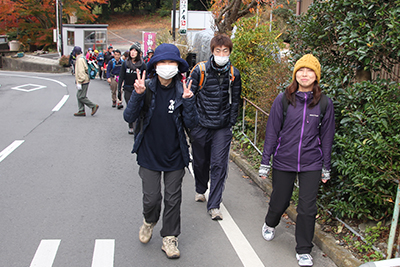 バス停から筑波山神社に向けて車道を歩いている３人の写真