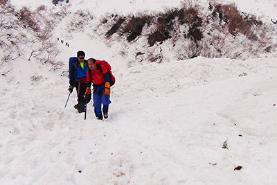 本谷のデブリの上を歩いて下山しているメンバーの写真